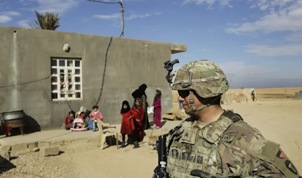 US Army soldier stands outside an Iraqi family home in al-Anbar in western Iraq on January 27, 2018 (AP)