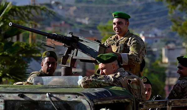 Lebanese army soldiers sit on their armored vehicle as they patrol the Lebanese side of the Israel-Lebanon border in the southern village of Kfar Kila, Lebanon, on October 13, 2023. (AP)