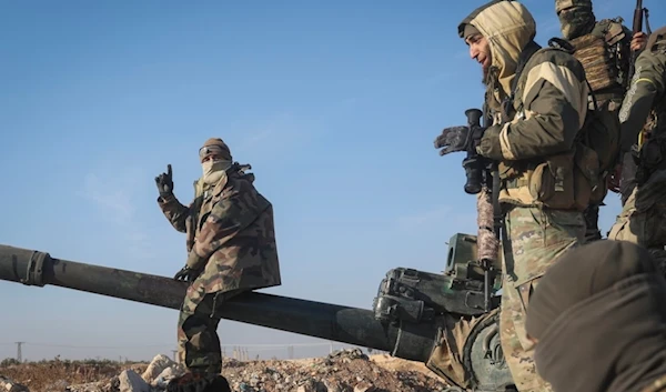 Syrian terrorists stand atop a seized Syrian army armoured vehicle in the outskirts of Hama, Syria, Tuesday Dec. 3, 2024. (AP)