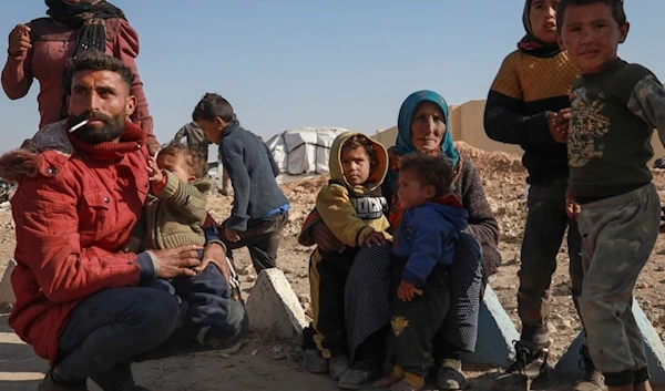 Internally displaced people sit in a camp in Tabqa city, Raqqa governorate, northern Syria, on Wednesday, December 4, 2024 (AP)