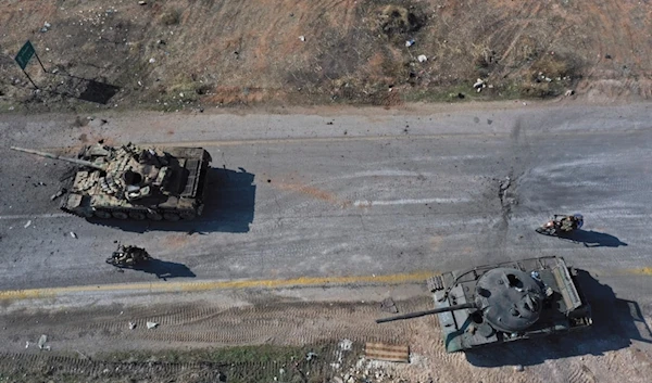 Syrian terrorists ride on motorcycles through abandoned Syrian army vehicles on a road in the outskirts of Hama, Syria, Dec. 3, 2024.(AP)