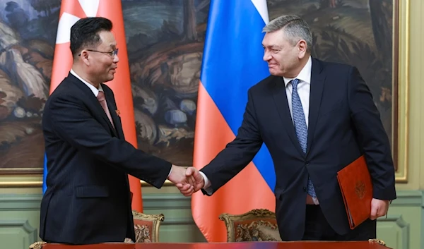 Deputy FM Andrei Rudenko, right, and his counterpart Kim Jong Gyu shake hands as they sign a protocol on exchanging instruments of ratification in Moscow, Russia, Dec. 4, 2024. (AP)