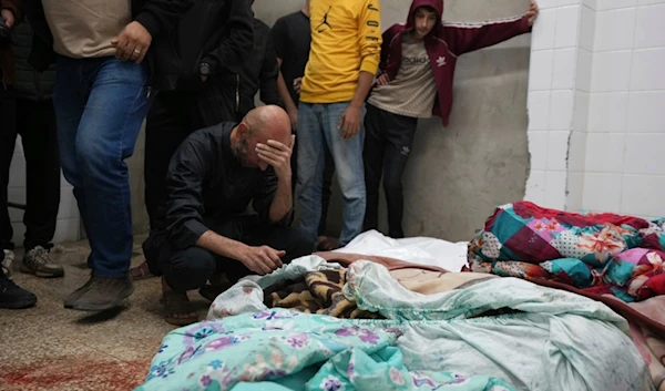 Palestinians mourn over relatives killed in an Israeli occupation bombardment in Nuseirat, central Gaza, as they stand in a hospital morgue in Deir al-Balah, Gaza Strip, Palestine, Nov. 20, 2024. (AP)