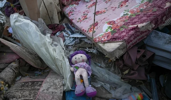 A doll lies among debris in the after math of an Israeli airstrike at the Muwassi camp near Khan Younis in the southern Gaza strip, on Thursday, December 5, 2024. (AP)