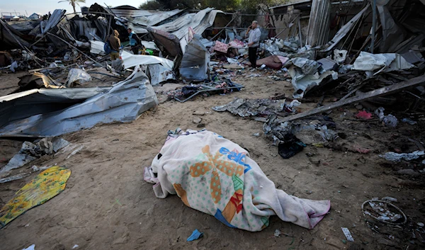 A body recovered earlier lies on the ground at the Muwassi camp near Khan Younis, in the southern Gaza Strip, on December 5, 2024. (AP)