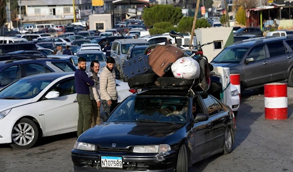 Syrians with their belongings queue as they cross to Syria through the Lebanese border crossing point of Masnaa, Bekaa Valley, Lebanon, Sunday, Dec. 8, 2024. (AP)