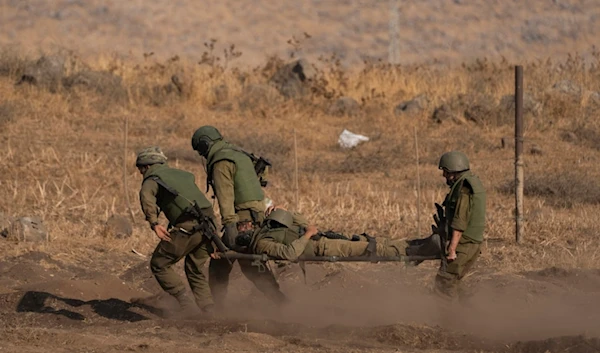 Israeli occupation soldiers carry a soldier on a stretcher during a drill as Israeli forces are stationed near the border with Lebanon, in occupied Palestine, Oct. 14, 2023. (AP)