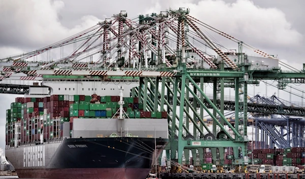 A sailboat passes a cargo ship unloading containers the port of Los Angeles in San Pedro on Thursday, June 15, 2023. (AP)