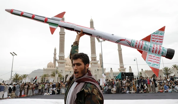 A Yemeni man raises a mock rocket during a rally against the US and 'Israel' and to support Palestinians in the Gaza Strip, in Sanaa, Yemen, April. 26, 2024. (AP)