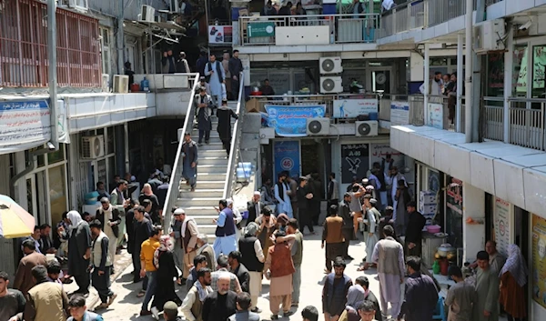 Afghans walk around a downtown currency exchange market in Kabul, Afghanistan, Monday, April 22, 2024. (AP Photo/Siddiqullah Alizai)