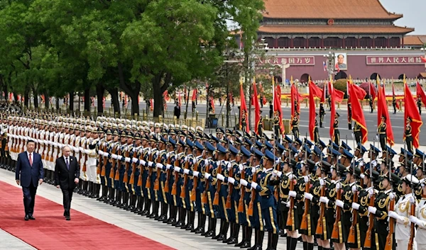 Chinese President Xi Jinping, left, and Russian President Vladimir Putin review the honor guard during an official welcome ceremony in Beijing, China, Thursday, May 16, 2024. (AP)