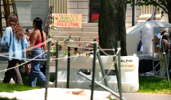 People walk past the remnants of an encampment of tents in Harvard Yard on the campus of Harvard University, Tuesday, May 14, 2024, in Cambridge, Mass. (AP)