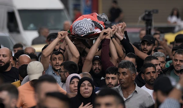 Mourners carry the body of Samer Rumaneh, draped in a Palestinian flag, who was killed in an Israeli military raid, during his funeral in the West Bank city of Nablus, Sunday, May 12, 2024. (AP)