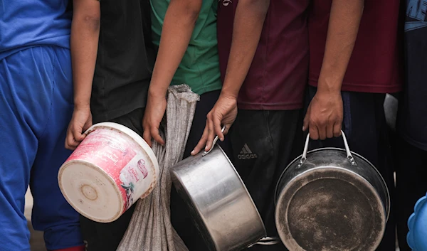 Palestinians line up for food distribution in Deir al-Balah, Gaza, May 10, 2024. (AP)