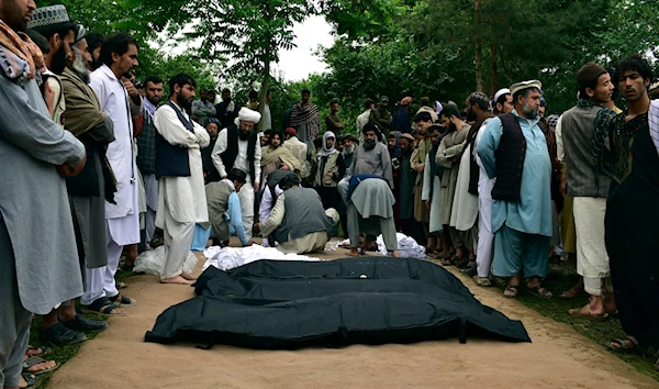 Dead bodies of Afghan people are placed on the ground after heavy flooding in Baghlan province in northern Afghanistan Saturday, May 11, 2024. (AP)