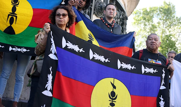 Demonstrators hold Kanak and Socialist National Liberation Front (FLNKS) flags during a gathering in Paris, May 16, 2024. (AP)