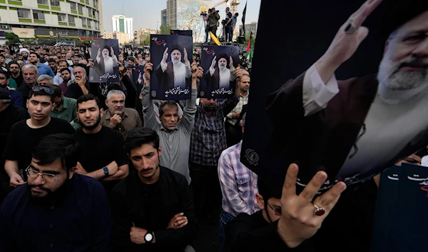 People hold up posters of Iranian President Ebrahim Raisi during a mourning ceremony for him at Vali-e-Asr square in downtown Tehran, Iran, May 20, 2024 (AP)