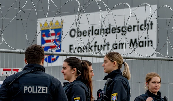 German police officers stand under barbed wire securing a temporary courtroom that was built for a trial starting on Tuesday in Frankfurt, Germany, Tuesday, May 21, 2024. (AP)