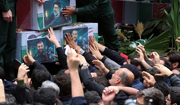 Mourners touch the coffins of President Ebrahim Raisi, Foreign Minister Hossein Amirabdollahian, and Raisi's chief bodyguard Gen. Mehdi Mousavi, in their funeral ceremony in the city of Tabriz, Iran, Tuesday, May 21, 2024 (AP)