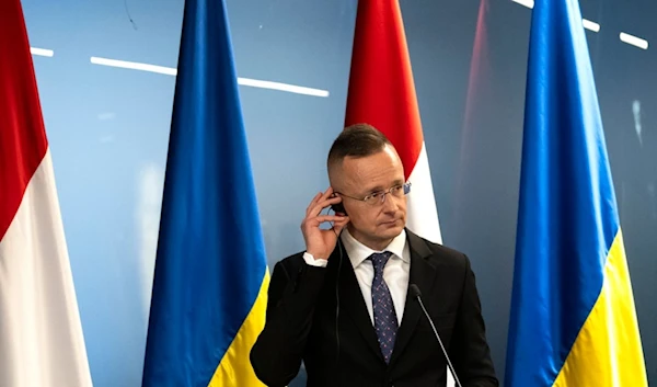 Hungary's foreign minister Peter Szijjarto reacts during a news conference with Ukrainian Presidental Office Andriy Yermak and Ukraine's foreign minister Dmytro Kuleba in Kamianytsia, near Uzhhorod, Ukraine, Monday, Jan. 29, 2024 (AP)