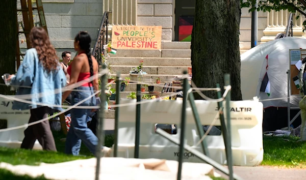 People walk past the remnants of an encampment of tents in Harvard Yard on the campus of Harvard University, Tuesday, May 14, 2024, in Cambridge, Mass. (AP)