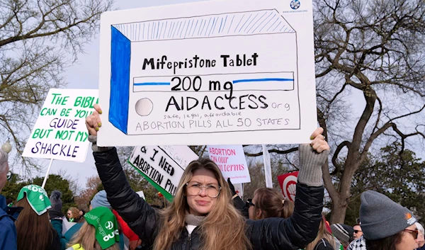 Abortion-rights activists holds a signs as they protest outside of the Supreme Court during a rally, March 26, 2024, in Washington. (AP)