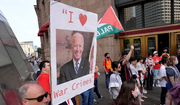 Demonstrators display a placard and chant slogans during a protest, Tuesday, May 21, 2024, in Boston. (AP)