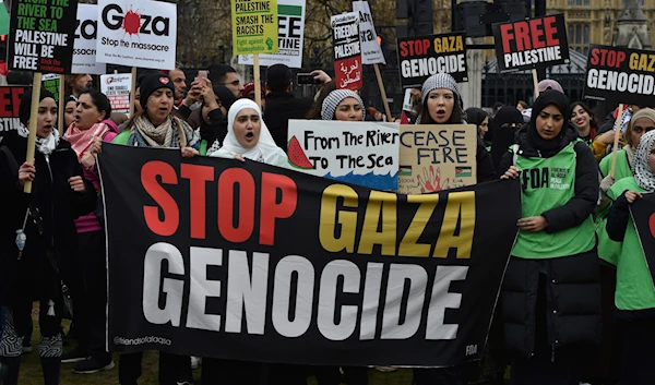 Pro-Palestinian protesters hold banners and placards ahead of a march in support of the Palestinian people in Gaza, in London, Saturday, April 27, 2024. (AP)