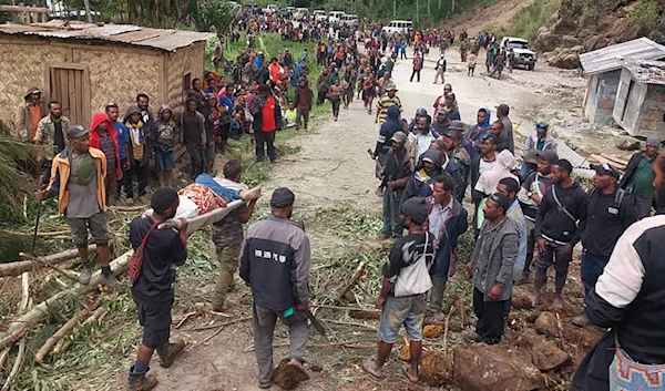 In this photo provided by the International Organization for Migration, an injured person carried on a stretcher after a landslide in Yambali village, Friday, May 24, 2024. ( International Organization for Migration via AP)