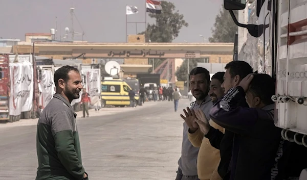 Egyptian truck drivers carrying humanitarian aids chat as they wait to cross the Rafah border crossing between Egypt and the Gaza Strip, Palestine, March.23, 2024. (AP)