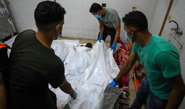 Palestinians carry the bodies of their relatives killed in the Israeli bombardment of Al Zawayda in central Gaza Strip, at the morgue of Al Aqsa hospital in Deir al Balah, Gaza Strip, on May 22, 2024. (AP)