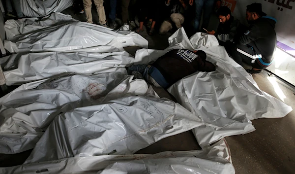 Palestinians mourn over the bodies of relatives killed by an Israeli airstrike, at a morgue in Rafah, Gaza Strip, Monday, May 27, 2024. (AP)