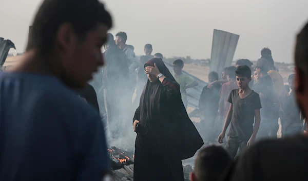 Palestinians look at the destruction after an Israeli strike where displaced people were staying in Rafah, Gaza Strip, occupied Palestine, May 27, 2024 (AP)