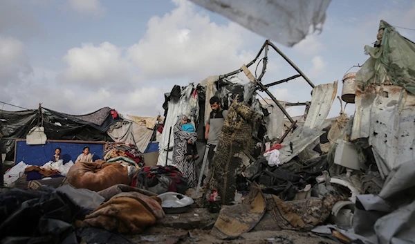 Displaced Palestinians inspect their tents destroyed by Israeli bombardment, adjunct to a UNRWA facility west of Rafah city, Gaza Strip, Tuesday, May 28, 2024. (AP)