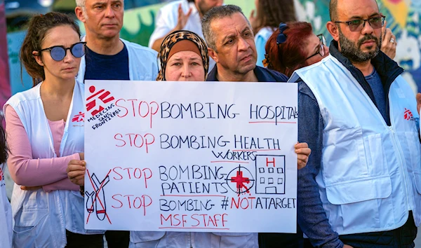 A member of international humanitarian group Doctors Without Borders holds a placard during a protest at Martyrs' Square in downtown Beirut, Lebanon, Monday, Dec. 4, 2023. (AP)