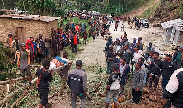 In this photo by the International Organization for Migration, an injured person is carried on a stretcher after a landslide in Yambali village, Papua New Guinea, Friday, May 24, 2024.