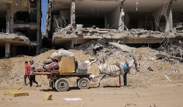 Palestinians salvage items from the destruction in the wake of the Israeli genocide in Jabaliya, northern Gaza Strip after Israeli occupation forces withdrew from the area, Friday, May 31, 2024. (AP)