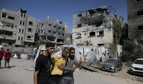 Palestinians help a wounded man after Israeli strikes in Nuseirat refugee camp, Gaza Strip, Saturday, June 8, 2024. (AP)