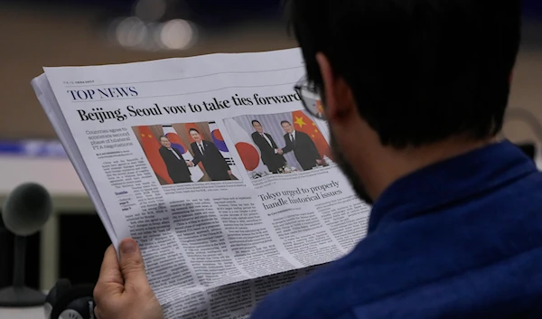 A journalist reads a local newspaper at the Ministry of Foreign Affairs office in Beijing, Monday, May 27, 2024. (AP)