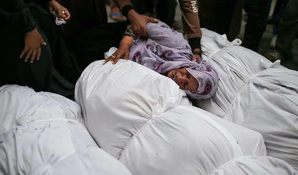 Palestinians mourn over the bodies of relatives killed in an Israeli airstrike, outside the morgue in Al-Aqsa Martyrs Hospital in Deir al Balah, the Gaza Strip, on June 10, 2024. (AP)