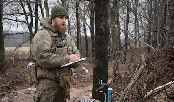 An officer of 12th Special Forces Brigade Azov of the National Guard writes down coordinates to fire a 155mm self-propelled gun M109 Paladin near Kreminna, Lugansk, Jan. 28, 2024. (AP)