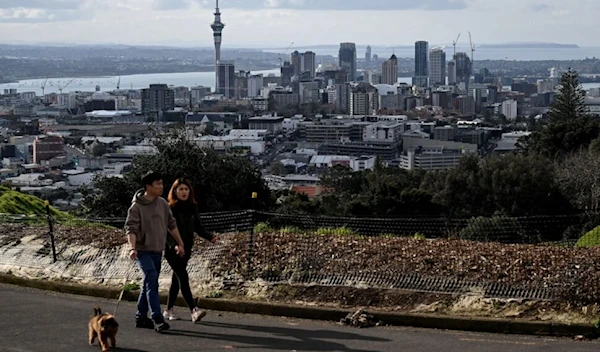 Residents walk their dog toward the summit of Mount Eden, a dormant volcano, in Auckland, New Zealand. (AFP)