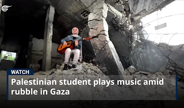 Palestinian student plays music amid rubble in Gaza