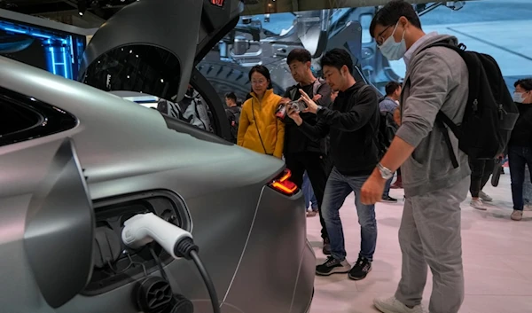 Visitors look at a Geely Galaxy E8 car during the Auto China 2024 in Beijing, Sunday, April 28, 2024. (AP)