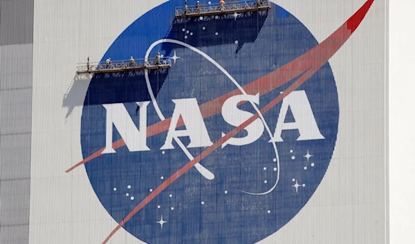 Workers on scaffolding repaint the NASA logo near the top of the Vehicle Assembly Building at the Kennedy Space Center in Cape Canaveral, Fla., Wednesday, May 20, 2020. (AP)