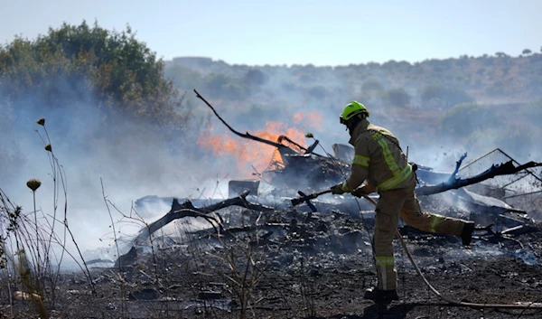 An Israeli firefighter works to extinguish a fire burning in an area near the community of Ramot Naftali, by the border with Lebanon, northern Israel, Tuesday, June 4, 2024. (AP)