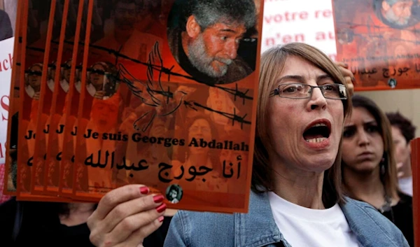 A supporter of Lebanese Georges Ibrahim Abdullah holds up his portrait with Arabic word read:" I'm Georges Abdullah," during a protest at the French embassy, in Beirut, Lebanon, Nov. 27, 2012. (AP)