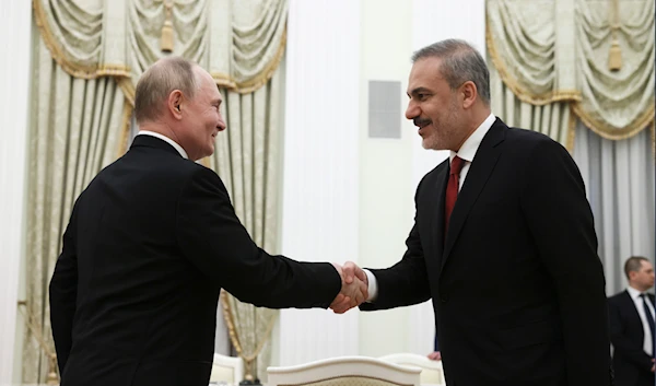 Russian President Vladimir Putin, left, and Turkey's Foreign Minister Hakan Fidan shake hands during their meeting at the Kremlin in Moscow, Russia, on June 11, 2024. (AP)