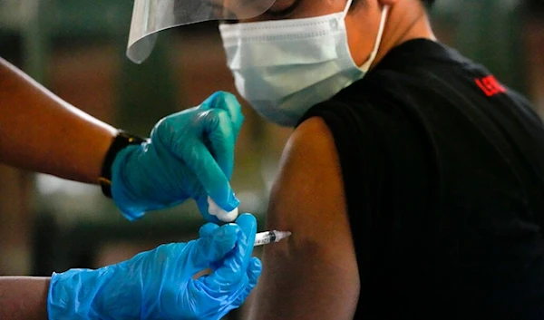 A man is inoculated with Pfizer COVID-19 vaccine during a nationwide vaccination drive at a school in Navotas, Philippines on Wednesday, Dec. 1, 2021. (AP)