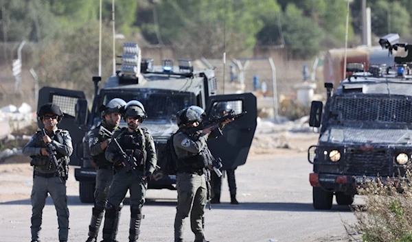 Israeli occupation forces take position outside the Ofer prison between Ramallah and Beitounia in the occupied West Bank, on November 24, 2023. (AFP)